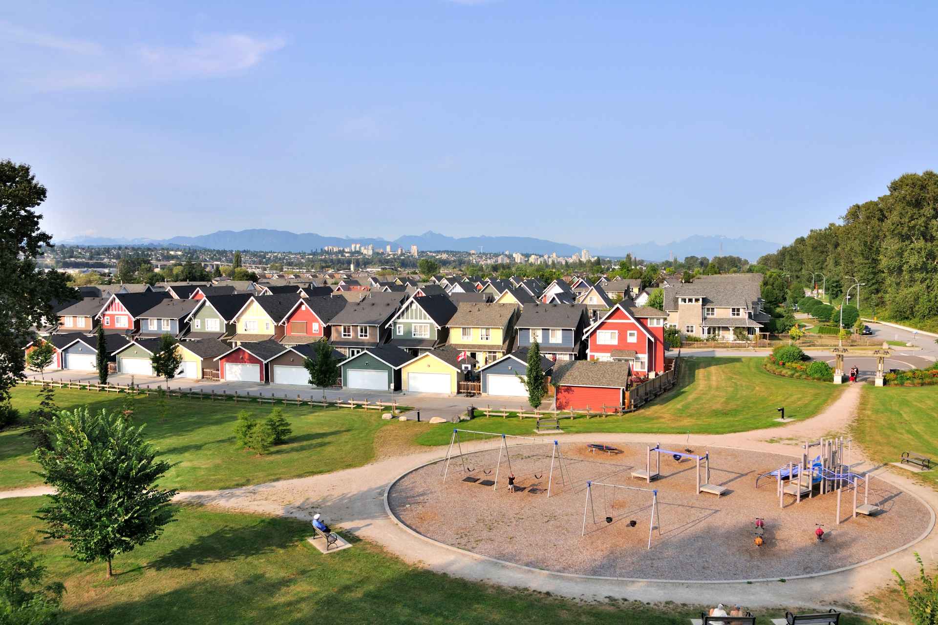 Aerial view of a colourful residential neighbourhood with various siding styles and a playground on the left.